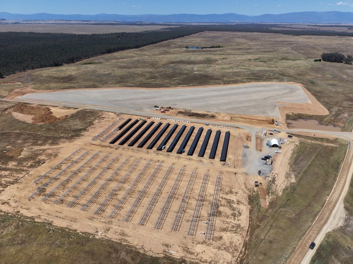 Wide aerial view of the Paskenta solar and storage microgrid site during construction, with mountains on the horizon