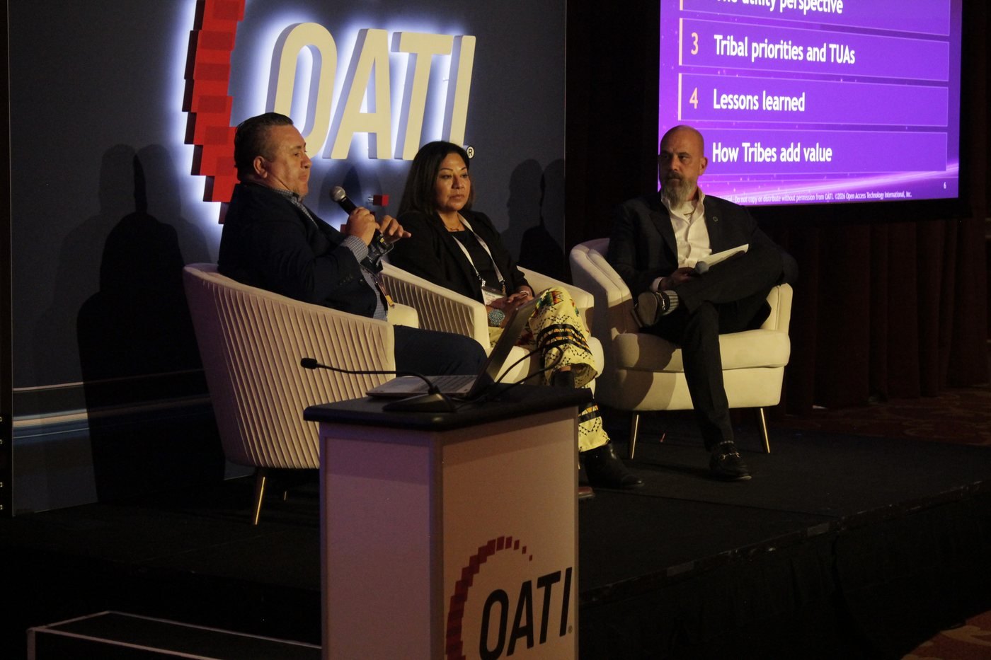 The Tribal Leadership Roundtable on stage, the discussion outline on screen